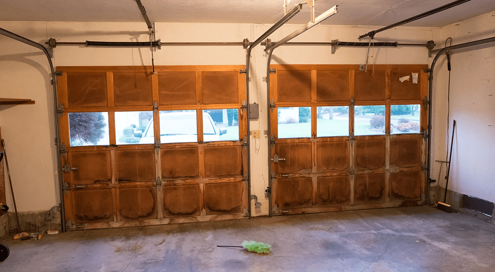 Empty garage with closed wooden doors.