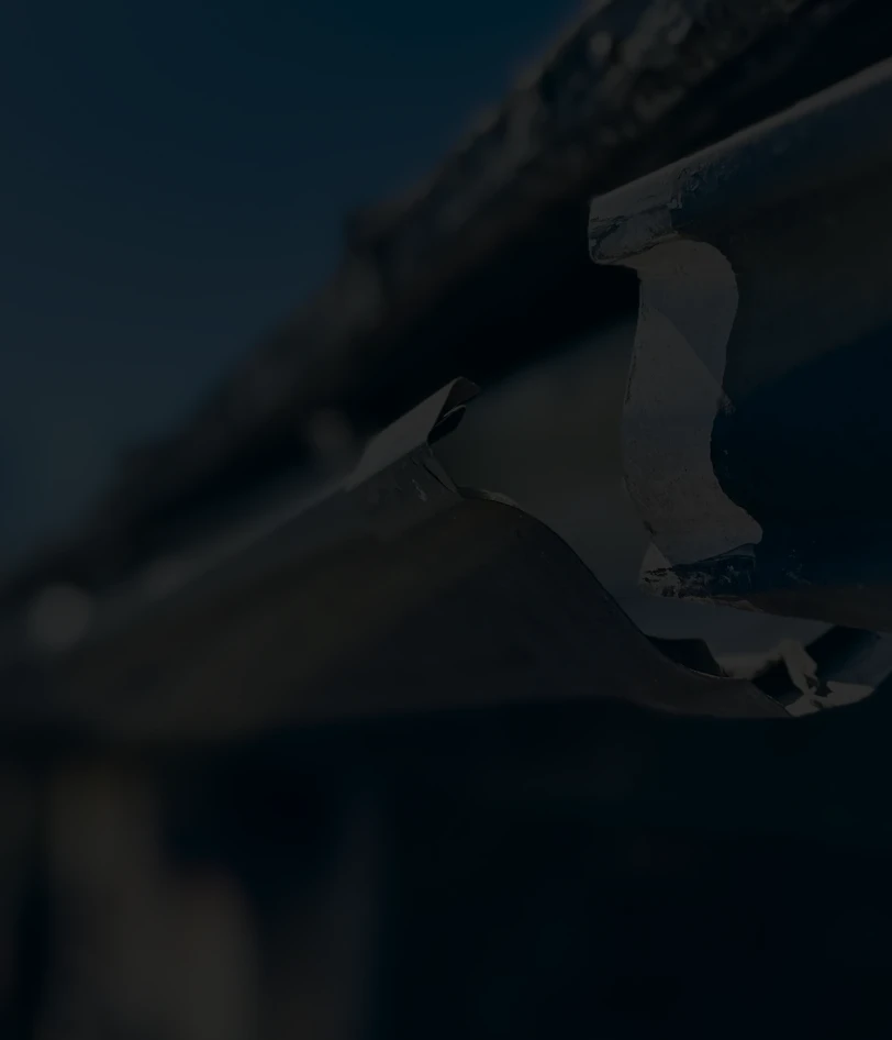Damaged metal gutter with dark background