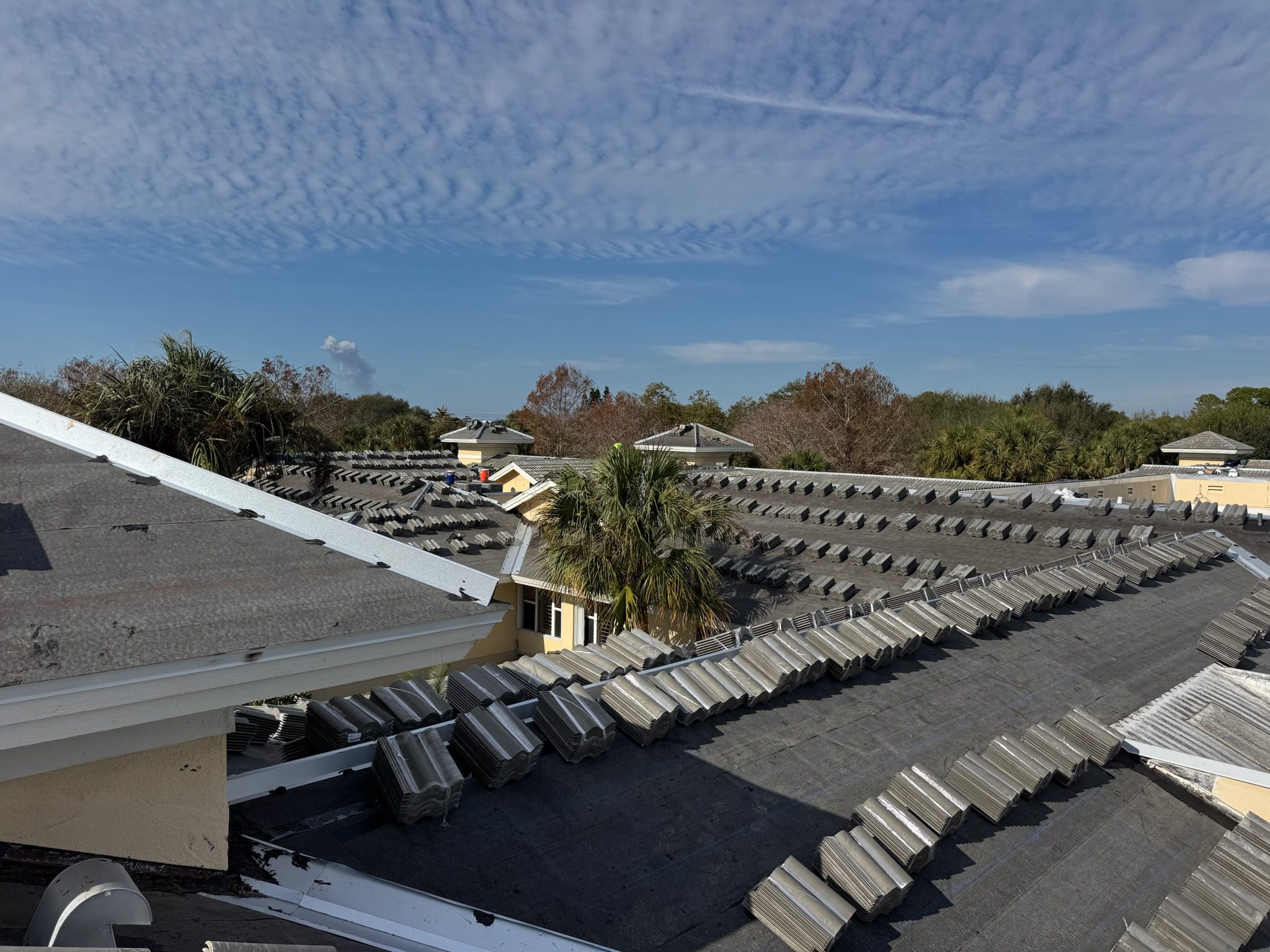 Traditional tiled rooftops under a clear, partly cloudy sky.